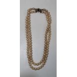 A double stranded pearl choker with a yellow metal clasp, stamped 9ct and  set with split pearls and