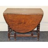 A 1920's oak drop leaf gateleg dining table, on barley twist and block supports, 73 x 93 x 134cm (