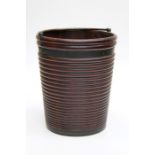 An early 19th century Irish mahogany peat bucket of ribbed form with coopered bands and swing