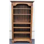 A reproduction oak and elm floorstanding open bookcase, the moulded and dentil cornice over five
