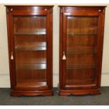 A pair of continental hardwood narrow display cabinets having shallow bowfront glazed panel doors,