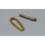 A yellow metal bar pin, stamped 15c,  weight approximately 1.3gm, plus a yellow metal chain,