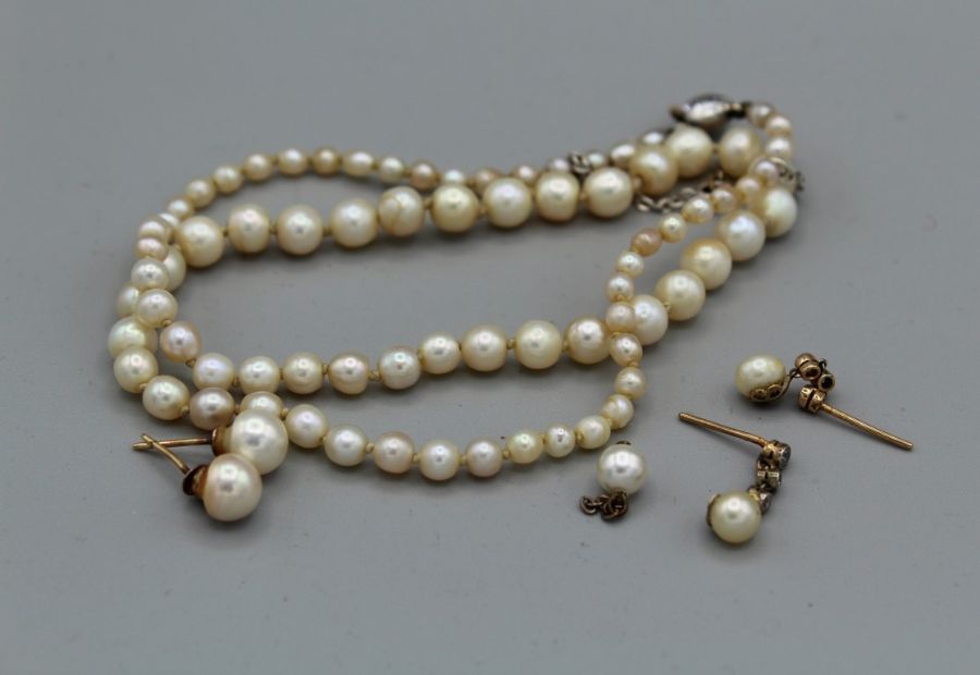 A pearl necklace with a collet set old mine cut diamond to the clasp, plus two pairs of pearl