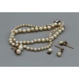 A pearl necklace with a collet set old mine cut diamond to the clasp, plus two pairs of pearl