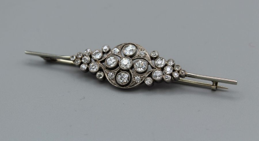 An Edwardian 18 carat white gold, diamond set openwork brooch. The four principal old cut stones