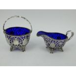 A Victorian ornately pierced silver basket with blue liner & matching sauce boat