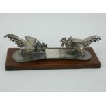 Victorian silver novelty fighting cockerels desk clip on oak mount, London 1891.