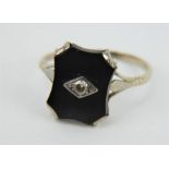 An Art Deco white gold black onyx set ring with central diamond.