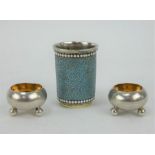 An enamelled Russian silver vodka cup by A Skovronsky & pair of Russian silver salts