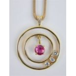 Diamond and ruby yellow metal double circle pendant on a 9ct gold snake chain