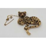 A 9ct. gold, sapphire, diamond and ruby set "Leopard" brooch, the recumbent leoprd with engraved fur