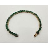 A precious yellow metal, emerald and diamond set line bracelet, having sets of four mixed round