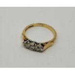 An 18ct gold three stone diamond ring, set three graduated round brilliant cut diamonds, size UK K