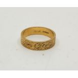 A textured 18ct. gold band, size UK N 1/2. (5.0g)