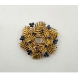 A 18ct. gold and sapphire set wreath brooch, having textured fir tree leaves in stepped mount set