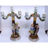 A pair of late 19th Century Continental ceramic candlesticks, with two figures and floral