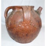 A large and impressive medieval earthenware three-handled vessel with pouring spout, c. 1500. It has