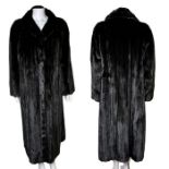 A fine quality full length mink coat in black with a black satin lining and internal swing ties with