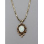 A 9ct gold opal foliate pendant on a 9ct gold box chain. The drop is 2.5cm on the pendant