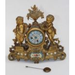 A late 19th century French gilt metal mantle clock, cast with putti, nesting chicks and rose garland