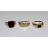 Three gentlemen's dress rings. Comprising a 9ct gold ring set with a black panel stone,