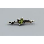 A peridot, diamond and seed pearl scrollwork brooch in yellow metal. Gross weight approximately 3.