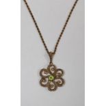 A peridot and seed pearl 9ct gold celestial pendant, on a twisted rope chain with 9ct stamped upon