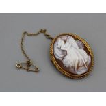 A hallmarked 18ct gold shell cameo brooch. Depicting a woman in a flowing dress, playing a lute.