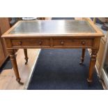 An early 20th century light oak olive green tooled leather topped office desk with four turned