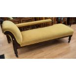 A late Victorian chaise longue with a back rail, in a mustard fabric.