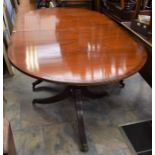 A Regency style mahogany extending dining table, on twin pedestal supports with reeded columns,