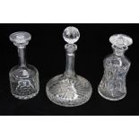 Three glass decanters, all with stoppers and two are crystal cut. Two are thin stem. Chips to them