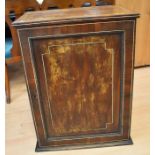 An early to mid-19th century mahogany inlaid cabinet with a single front door that opens to reveal a