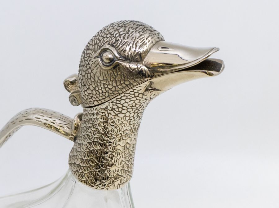 A novelty glass and plate mounted claret jug in the form of a duck, with a glass body. (wearing to - Image 2 of 2