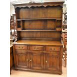 A reproduction oak dresser with two cupboard doors to the base, three drawers above and an upper