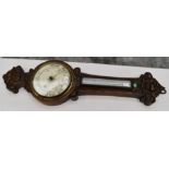 A 19th century oak wall barometer with carved detail