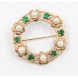 An emerald and pearl 9ct gold circular brooch, open form set with alternate round cut claw set