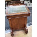 A 19th century walnut Davenport with a gallery top, green leather insert, four side drawers and four