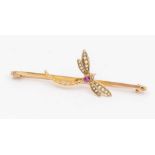 An Edwardian ruby and pearl set yellow metal bar brooch in the form of a dragonfly, the body set