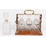 A mid 20th Century three decanter tantalus along with glass decanter with silver collar