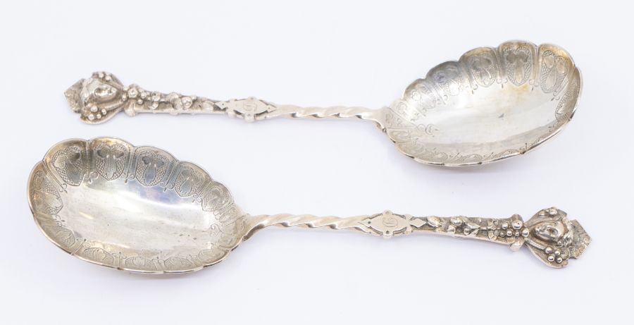 A pair of Victorian silver serving spoons with twisted stem, mask and berry ornamentation to the