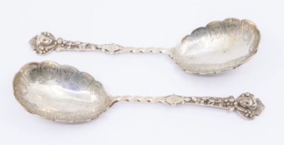 A pair of Victorian silver serving spoons with twisted stem, mask and berry ornamentation to the