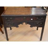 An early 18th century oak lowboy with a single drawer above two side drawers, brass swan-neck