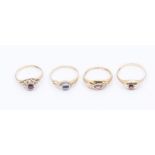 A collection of four stone set 9ct gold rings to include a sapphire ring set with a cabochon oval