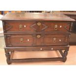 An early 18th century oak two-drawer chest on stand with brass lion's head handles, not original. In