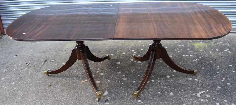 A reproduction George III mahogany D-end dining table with a wide single leaf and set on splayed