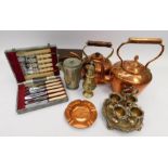 A collection of copper and silver plated items, including silver napkin rings and piano music