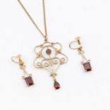 An Edwardian 9ct gold garnet pendant, comprising a wire work frame with floral decoration set to the