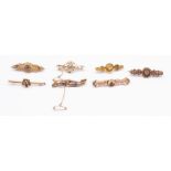 A collection of seven Edwardian gold bar brooches, various designs to include three 15ct gold