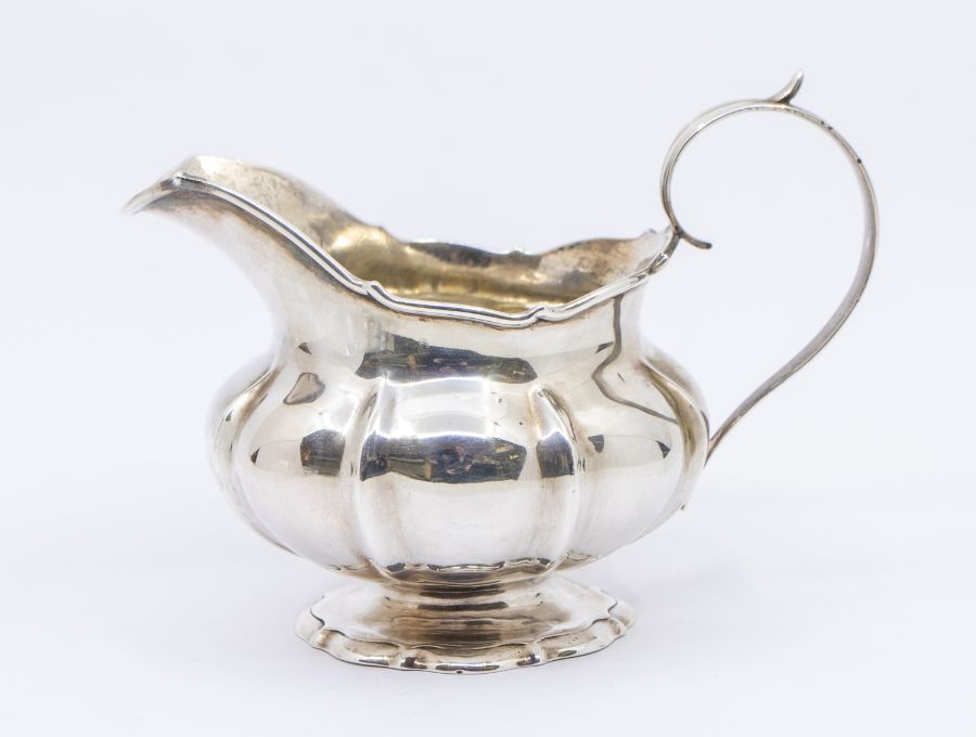 A William IV silver gadroon bodied handled milk/cream jug, with initialled front and gilt